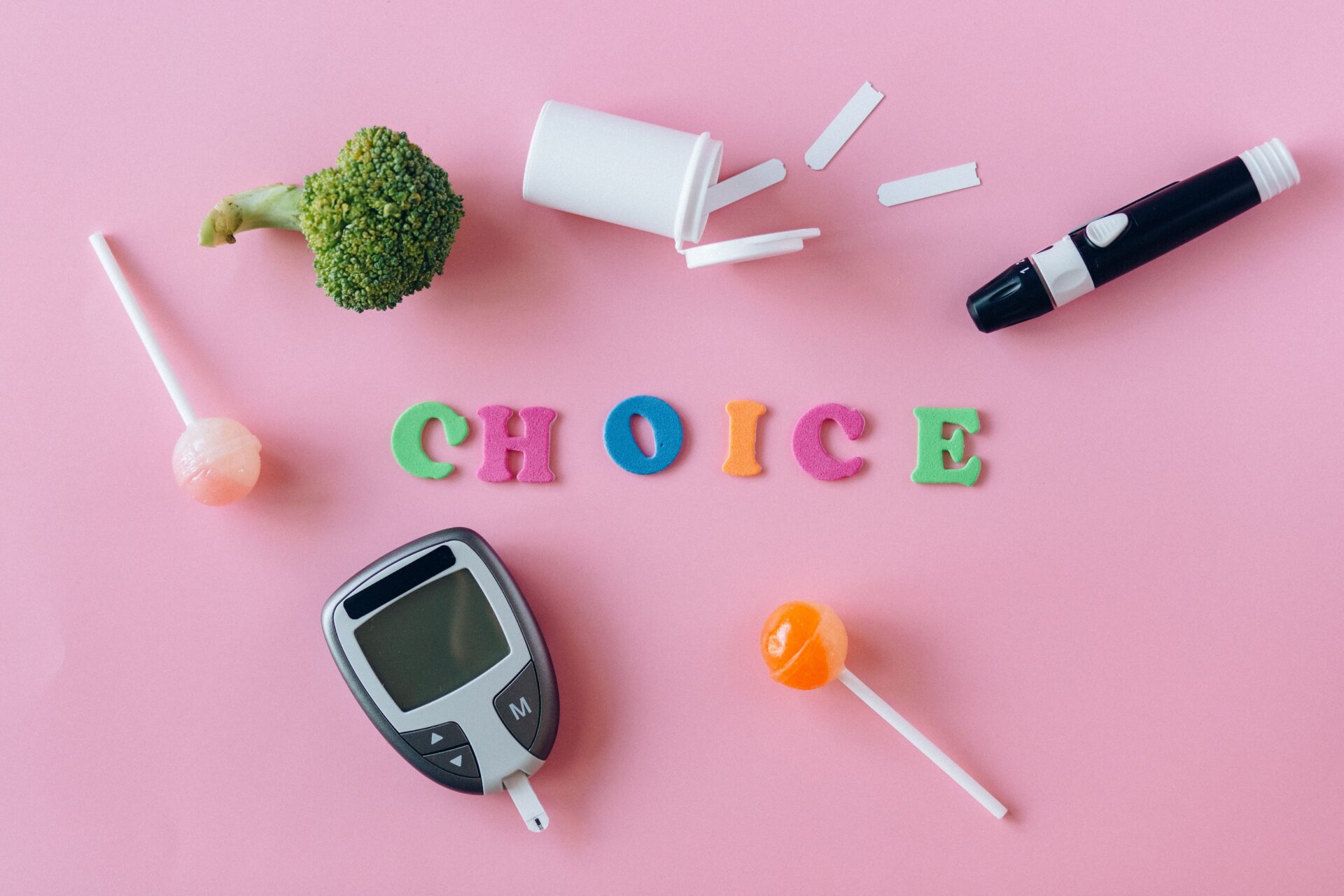 Artistic depiction of choosing between healthy food and sweets with glucose monitor on pink background.